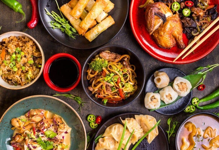 A selection of Chinese food dishes, including spring rolls, dim sum, noodles, and more
