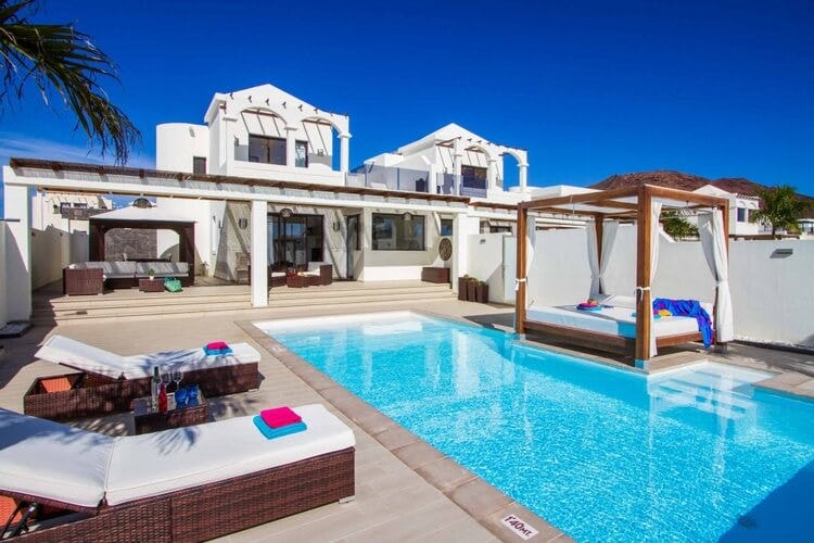 white villa with pool and sun bed