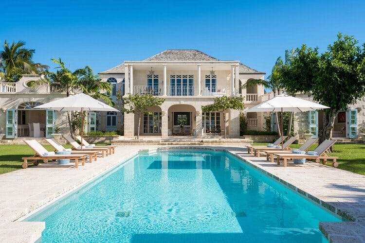 mansion style house with pool complete with sun loungers