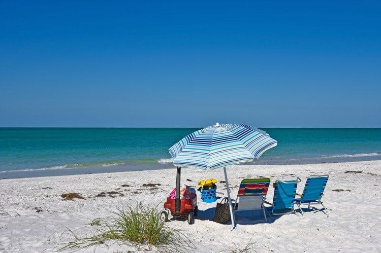Holmes Beach white sand beach with sun loungers and a parasol