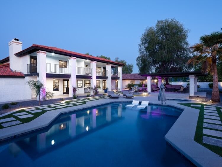 glamorous white villa with pool at dusk