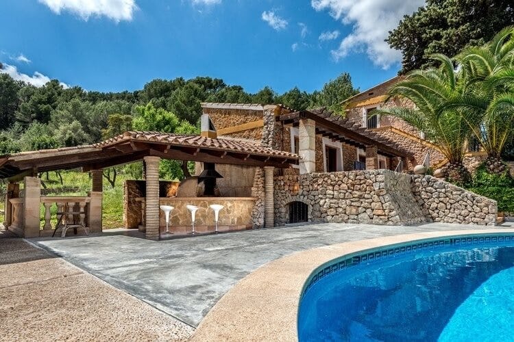 rustic stone villa with pool and bar stools