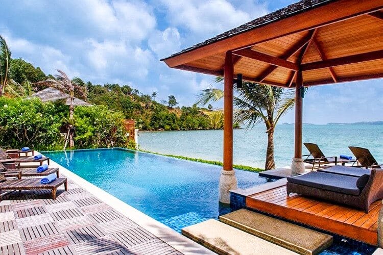 pool and covered seating area next to ocean