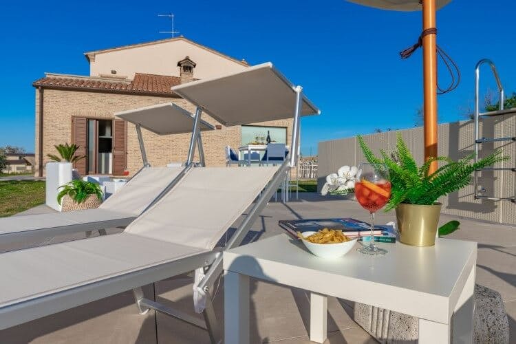 Villa Clair Italian vacation rental with sun loungers, parasol, and table set up with drinks and snacks