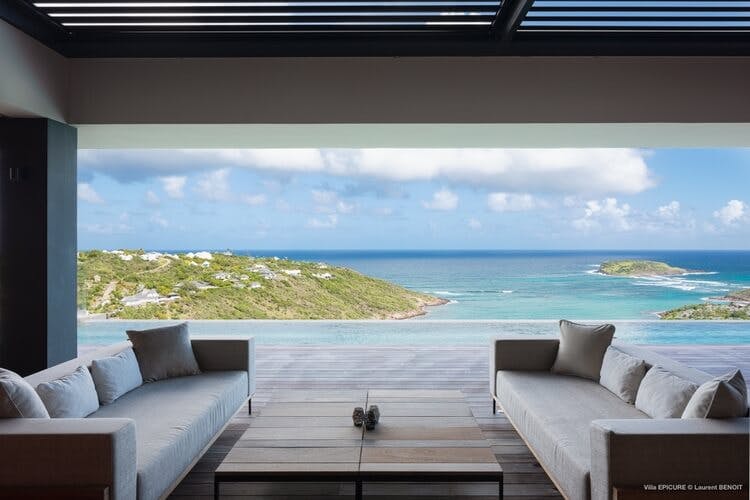 a lounge looking out over an infinity pool and Caribbean sea