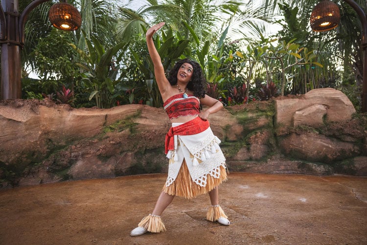 Where to find characters at Disney World - a person dressed as Moana posing in front of tropical trees
