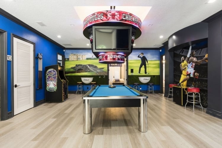 Sport themed game room with pool table, multiple TV screens and arcade games