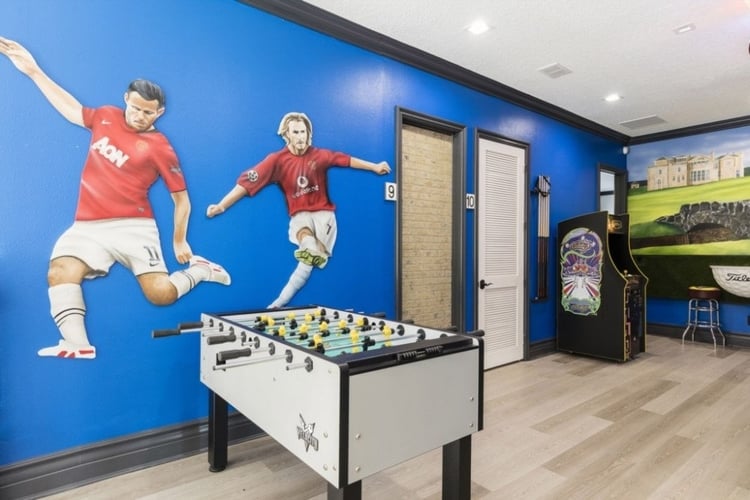 Game room with foosball table and Manchester United footballers painted on the wall