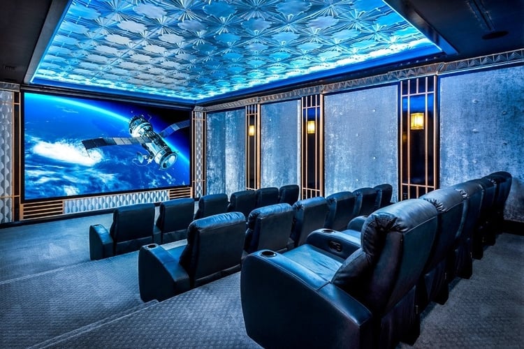 This luxury villa has a home theater with tiered cinema-style seating and a projector screen