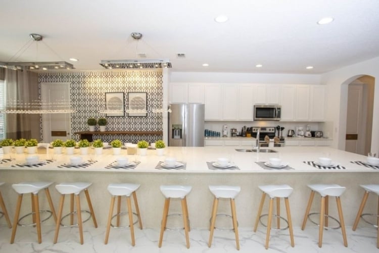 There is a modern fully equipped kitchen with a breakfast bar and bar stool seating