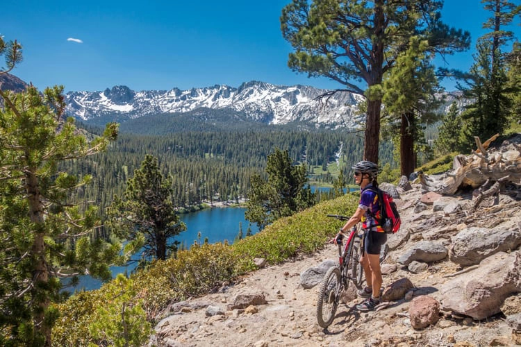 A person on a bike looking out over a lake in Mammoth Lakes
