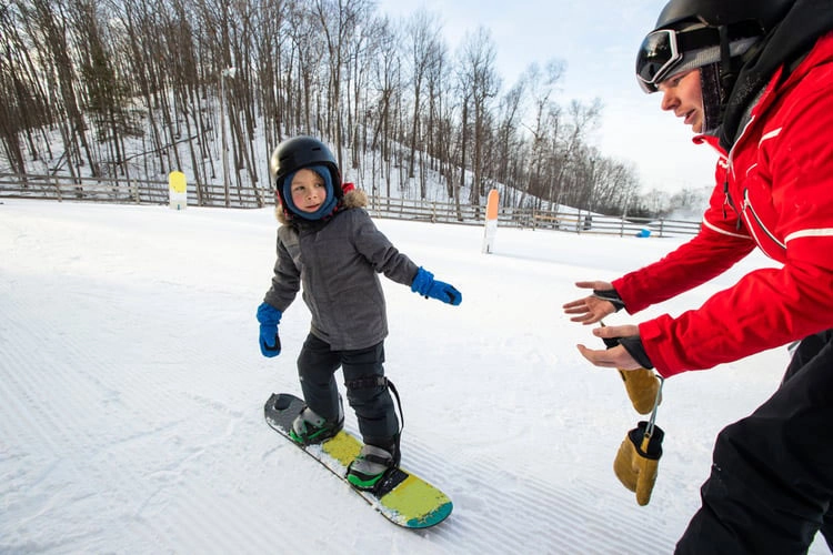 A young person having a snowboard lesson
