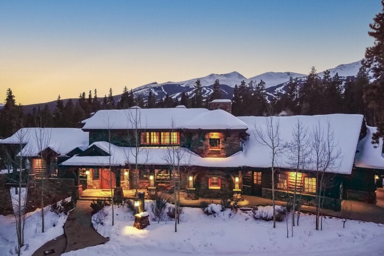 A large house in the mountains covered in snow