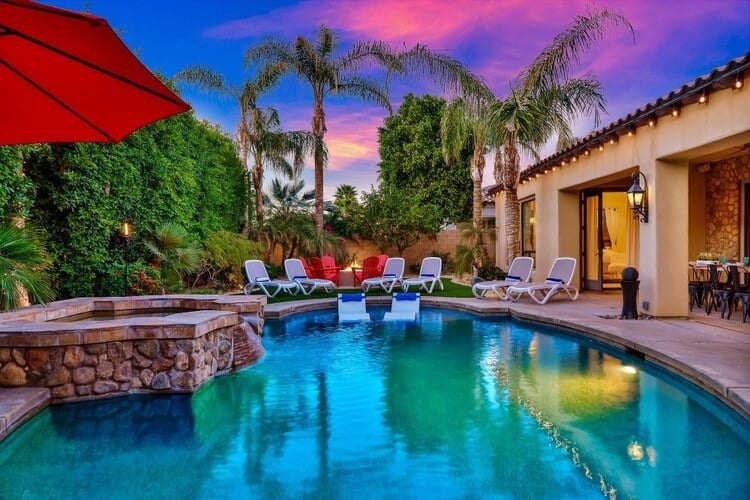 A beautiful Palm Springs villa with a large private pool, outdoor seating and palm trees