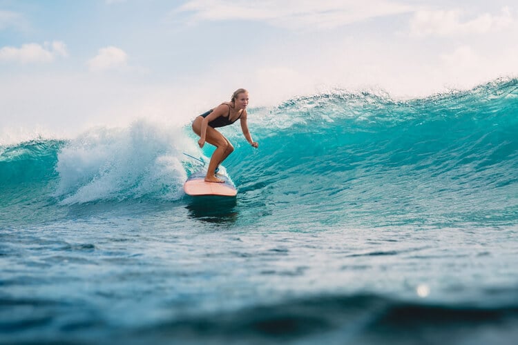 A lady surfing a large wave