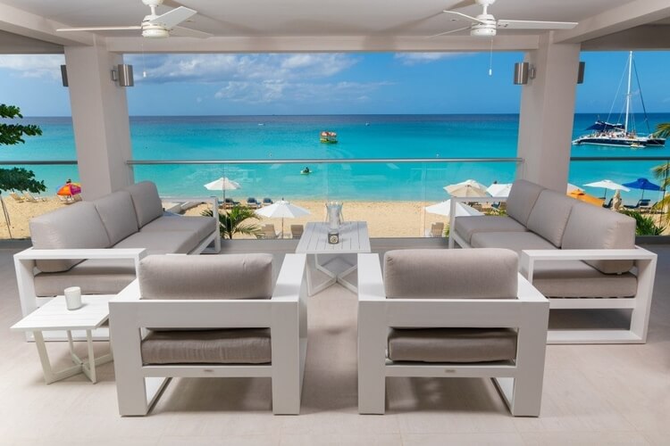 A dining area in a luxury villa overlooking a white sand beach and the Caribbean Sea