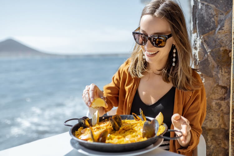 A woman enjoying a dish of paella