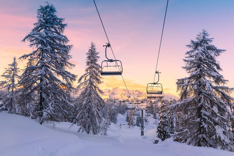 Ski lifts against a pastel sunset sky