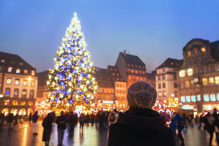 A woman in a woolly hat looks the Christmas tree in Strasbourg's market square