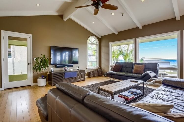 The interior lounge of a San Diego family villa with a Pacific view and comfortable leather couches