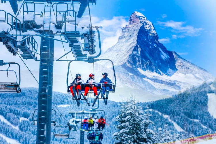Skiers in a lift with the Matterhorn in the background