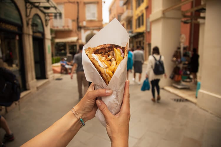 A woman holding a large gyros in Crete