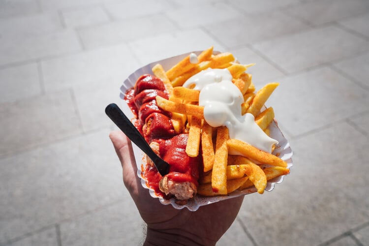 A tray of currywurst, fries and mayonnaise
