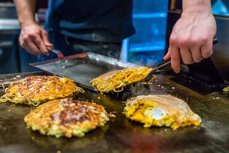 Japanese okonomiyaki being made on a hot plate