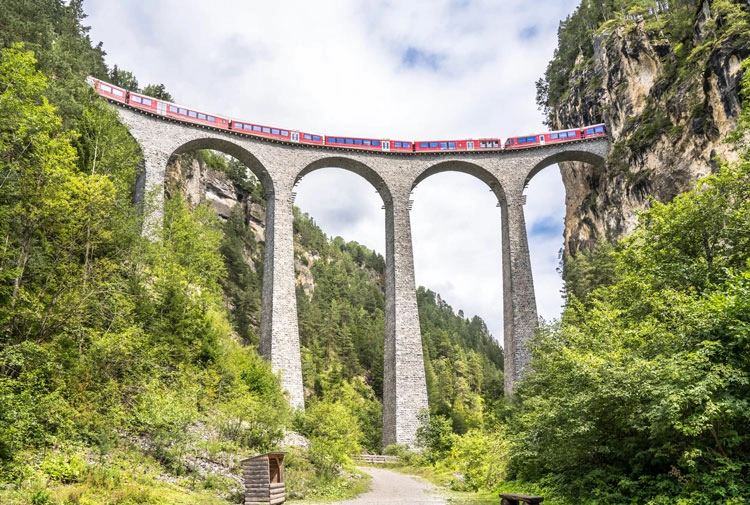 The red Bernina Express train crossing a viaduct in Swtizerland