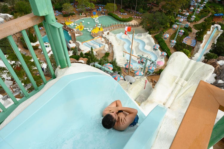 Guide to rides at Disney World - a person sliding down a steep water flume