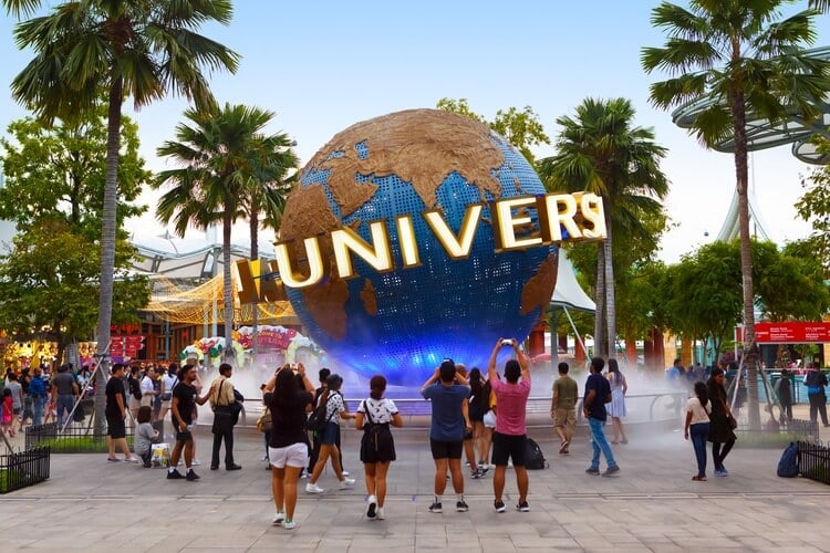 people at the Universal Studios park in florida, looking at the sign that reads Universal