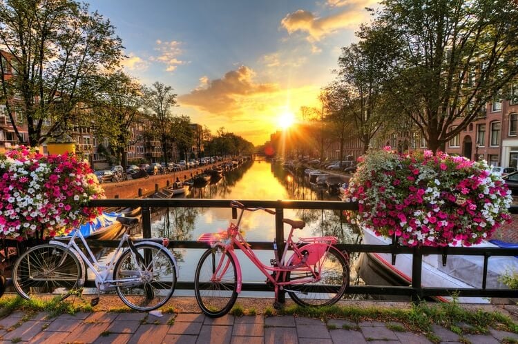 amsterdam canal at sunset with bikes in foreground