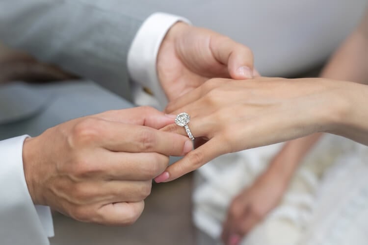 A man putting a ring on a woman's finger
