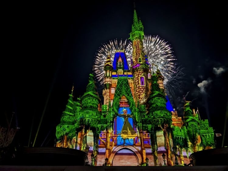 cinderella's castle lit up with fireworks in background