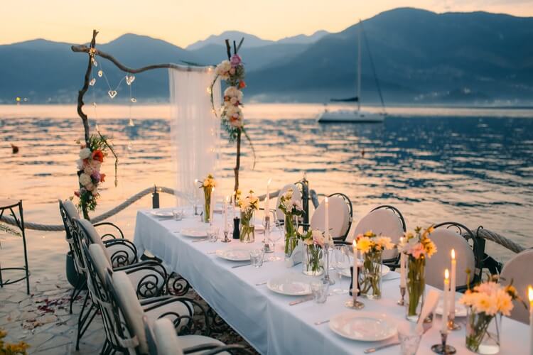 table beside a lake with ceremony arch