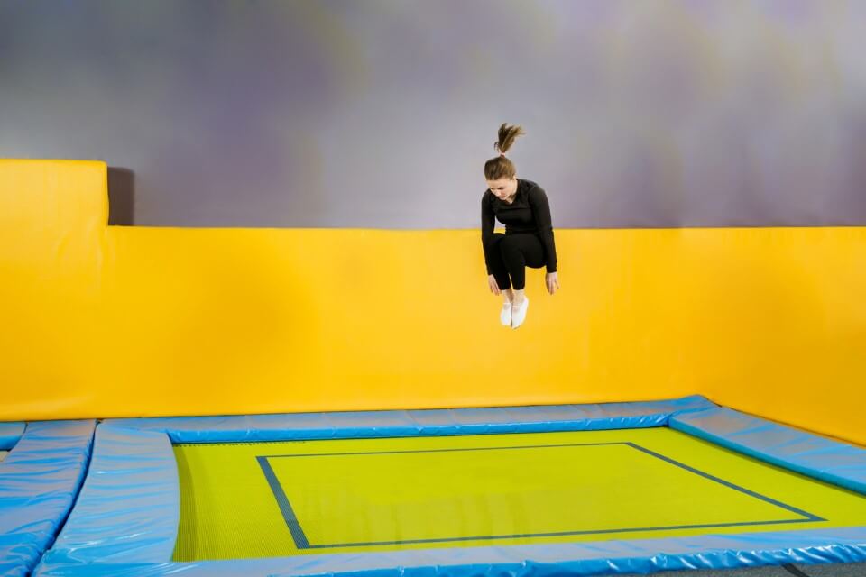 A woman jumping on an indoor trampoline