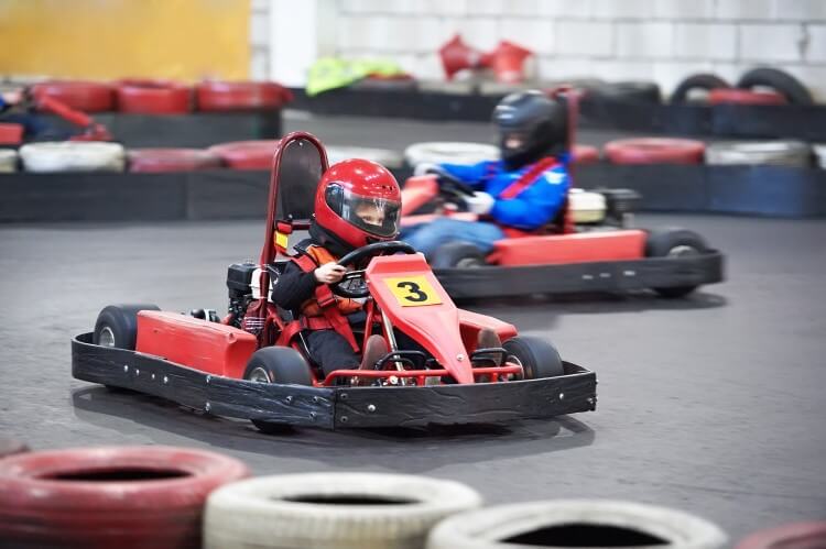 Children driving at an indoor karting center.