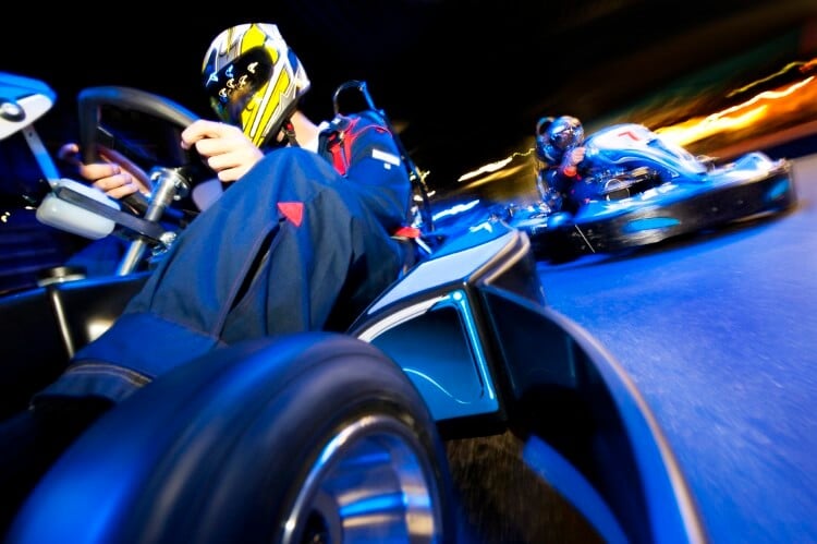 Close-up of go kart driver bring overtaken. 
