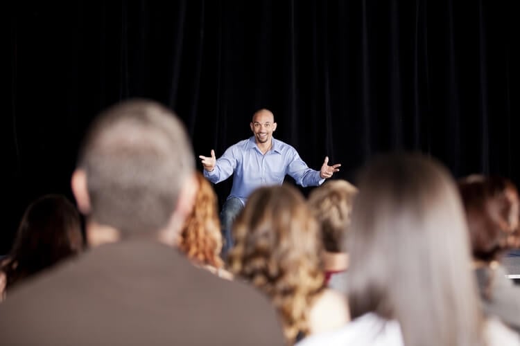 man performing comedy on stage