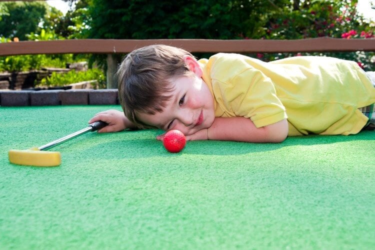 Young child aiming the next shot. 