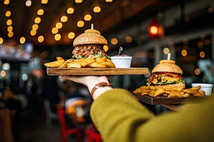 burgers being carried to table in a restaurant