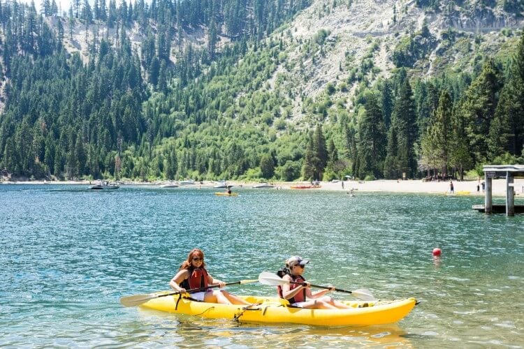 Two women in a yellow kayak on Lake Tahoe in the summer