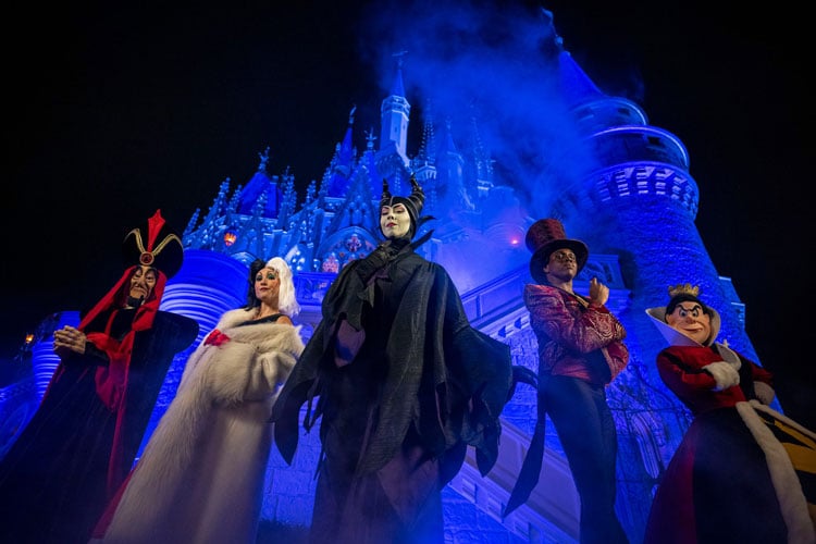 Costumed performers dressed as Maleficent, Cruella DeVille, Jafa, Dr Facillier, the Queen of Hearts in front of Cinderella's Castle at the Disney World Halloween event