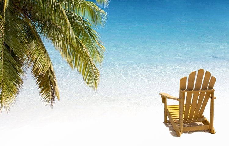 A yellow chair on a white sand beach in the Cayman Islands - the best places to visit in April