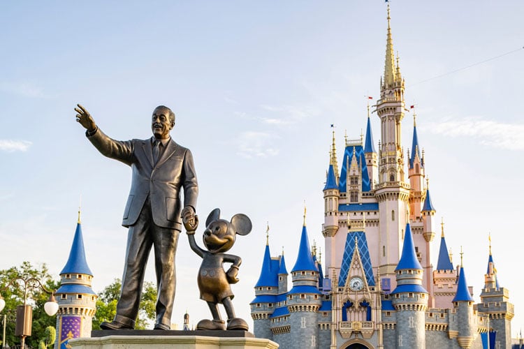 View of Walt Disney statue and Cinderella's Castle at Disney World Orlando - The best places to visit in August