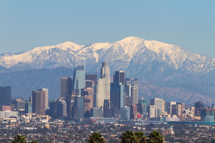 The best places to visit in December - Los Angeles skyline against snowy mountains