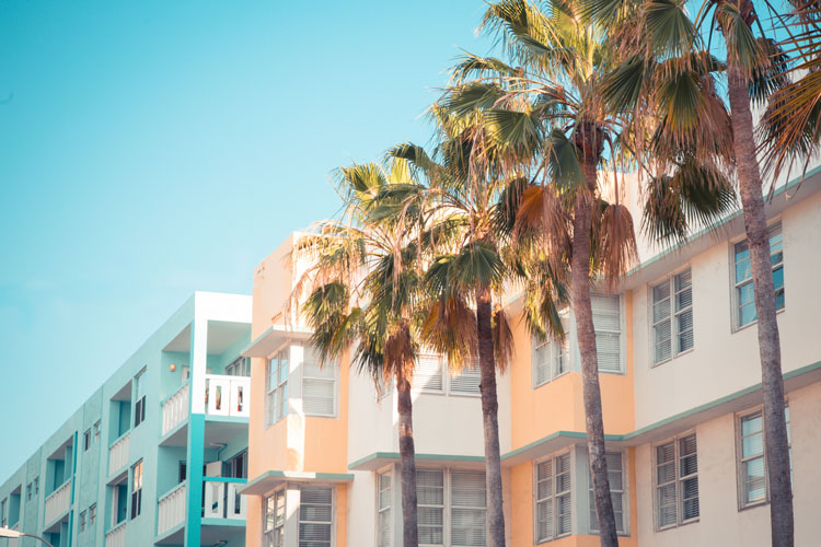 Art Deco style pastel colored buildings and palm trees in Miami