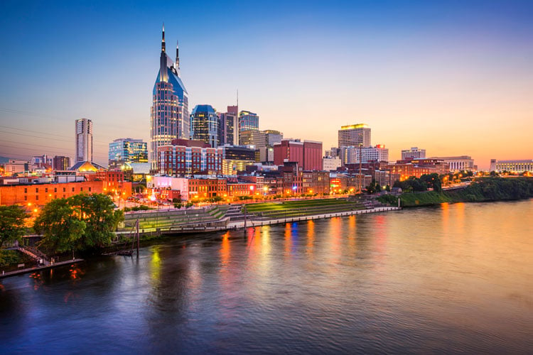 Sunset over a river and skyscrapers in Nashville - best places to visit in March