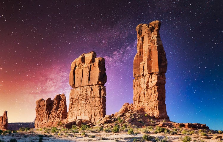 Rock formations in the desert under a clear starry star in Arches National Park - best places to visit in March