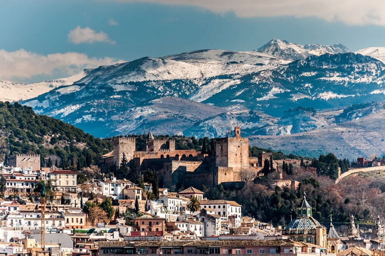 The best places to visit in November - snow covered city in front of mountains in Andalusia